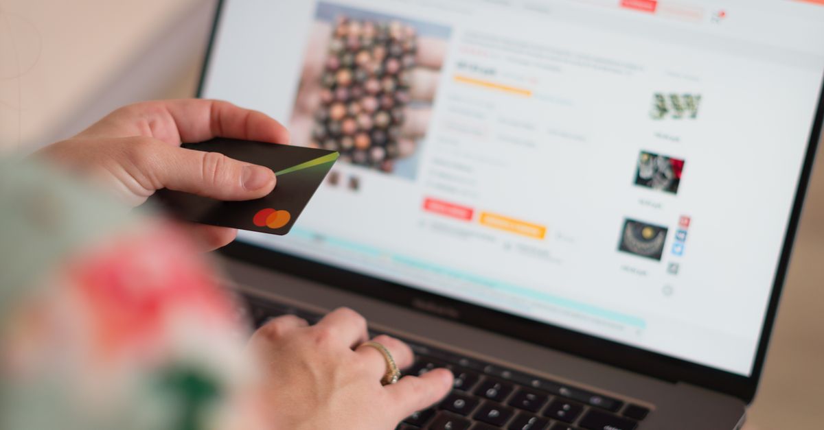 Engaging in online shopping using a credit card with a laptop for convenience and ease.